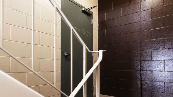 Une porte, une rampe d'escaliers et un mur.