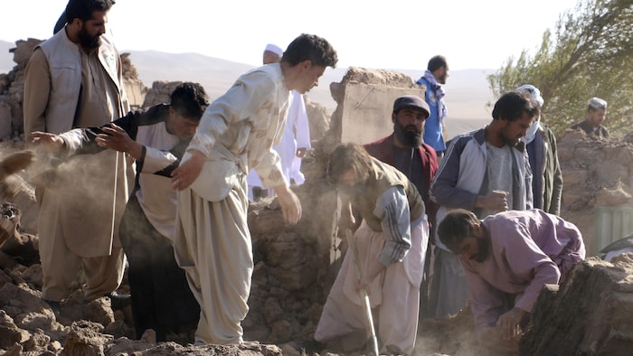 Men search for victims after the earthquake that struck the Zinda Jan district of Herat Province, Sunday, October 8, 2023. 