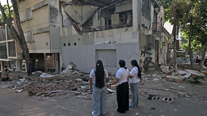 Des femmes observent un bâtiment endommagé après un séisme à Cali, en Colombie, le 10 août 2026.