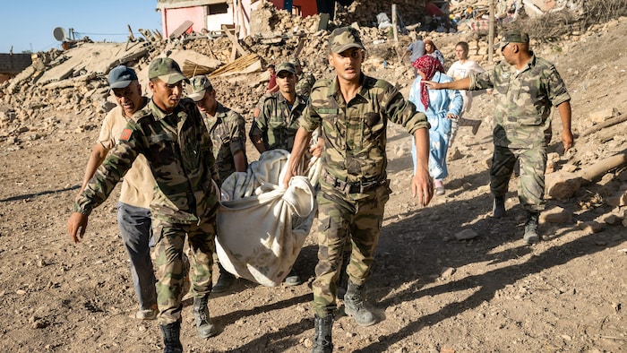 جنود مغاربة يجلون جثة من منزل دمره الزلزال في قرية تافغاغت الجبلية جنوب غرب مدينة مراكش.