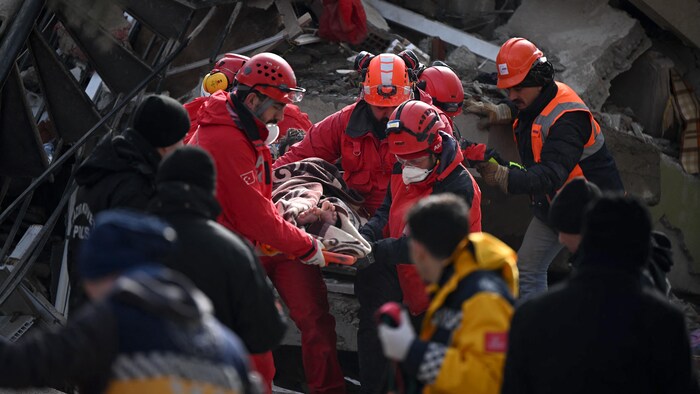 Rescue workers carry a rescued young man on a stretcher through the rubble of buildings in Kahramanmaras, the epicenter of the quake.