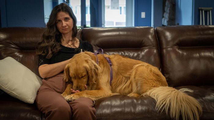 Une personne avec un chien sur un sofa.
