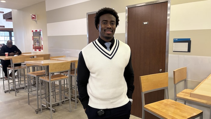 Sekouba Traoré a un mini afro, porte une cravate et a les mains dans la poche.