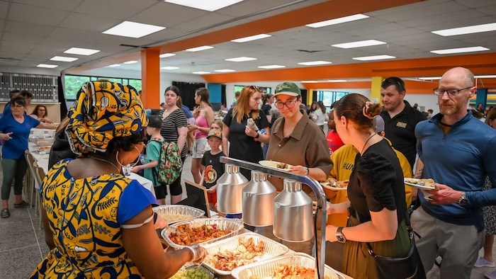 Des gens se servent des mets internationaux à un buffet.