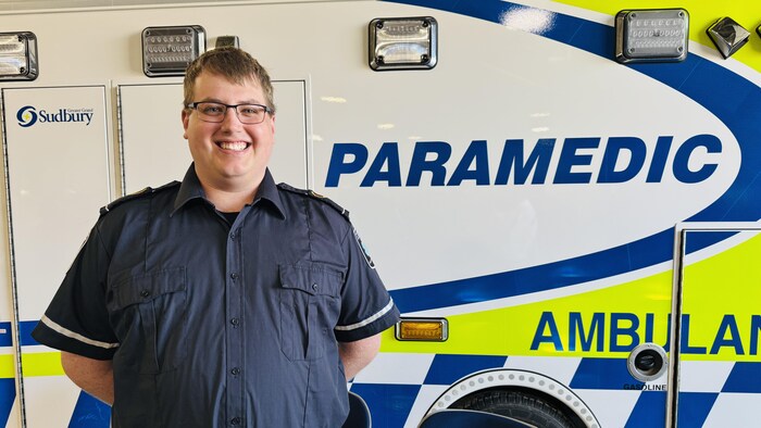 Un ambulancier devant une ambulance.