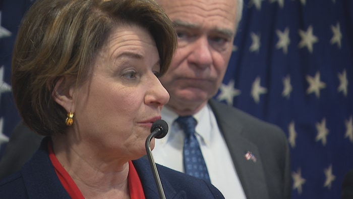 Les sénateurs démocrates Amy Klobuchar et Tim Kaine, devant des drapeaux américains.