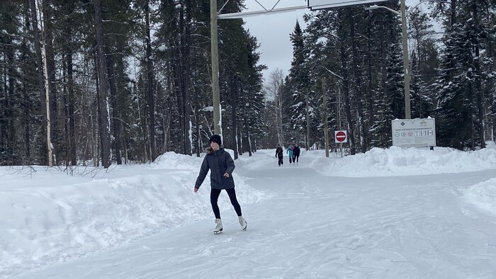 Une fille patine sur un sentier glacé.

