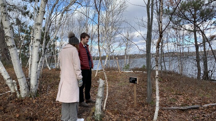 Deux étudiants debout dans les bois, tout près d'un lac