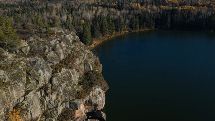 Une falaise offre une vue sur un lac.