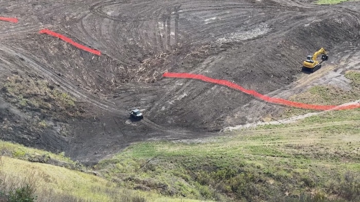 Un véhicule circule sur le site du glissement de terrain à Old Fort.