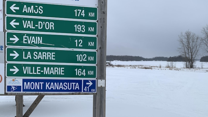 Des panneaux indiquent la distance à parcourir pour se rendre à Amos, Val-d'Or, Évain, La Sarre et Ville-Marie.
