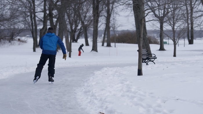Un homme patine sur un sentier de glace.