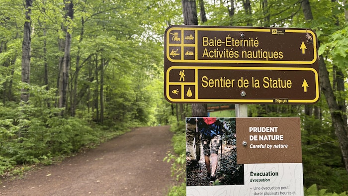 Une affiche qui donne les directions dans un sentier.