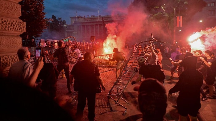 Des manifestants lancent des barrières et des fumigènes sur les forces de police.