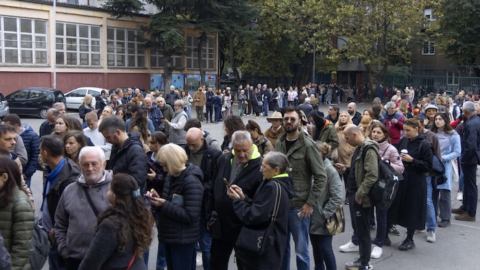Des électeurs font la queue devant un bureau de vote pour les élections législatives anticipées en Serbie, à Belgrade, le 25 octobre 2026.