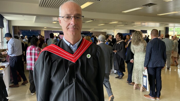 Serge Demers in a room where there are many people.