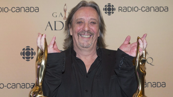 A man holds two statuettes. serge fiori died age 73