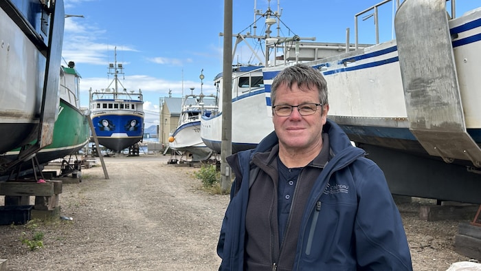 Serge Langelier devant des bateaux.