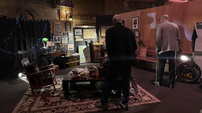 Des hommes observent une exposition. 