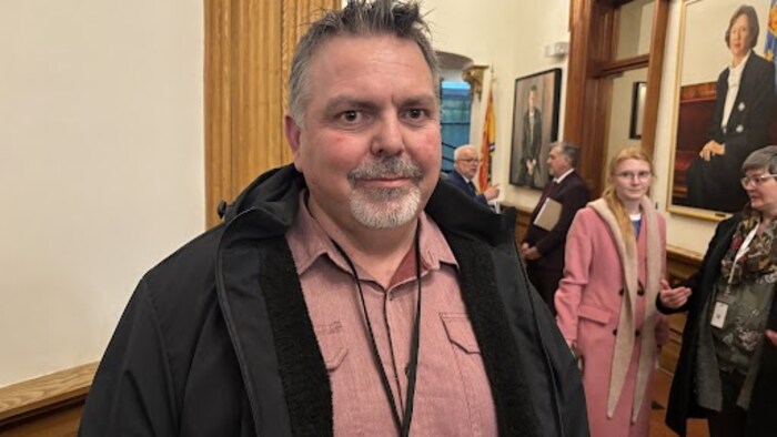 Serge Plourde pose pour la photo, à l'intérieur de l'Assemblée législative du Nouveau-Brunswick.