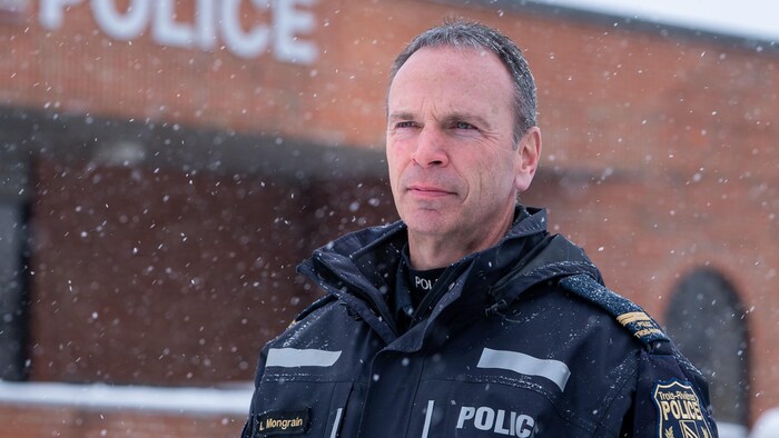 Luc Mongrain devant l'édifice de la police de Trois-Rivières par une journée enneigée.