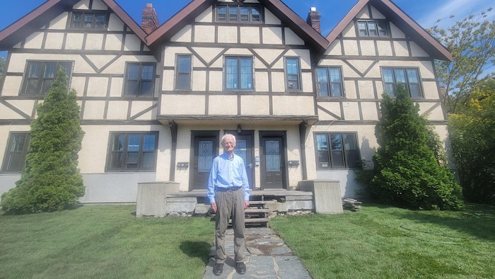 David Lee devant le bâtiments de style arts et métiers connu sous le nom des appartements Lee, sur l'avenue Murdoch à Rouyn-Noranda.