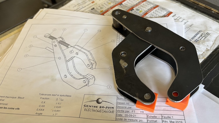Une serre-pince posée sur son plan de fabrication