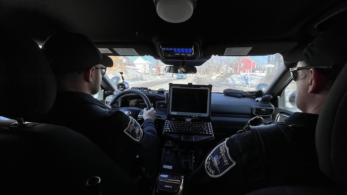 Des policiers dans une auto.
