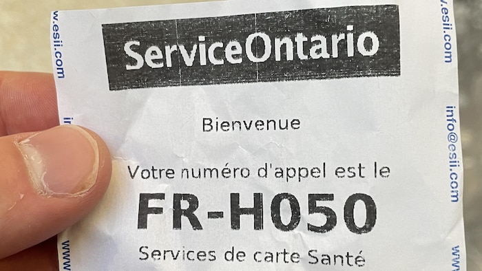 Un homme tient le billet dans les mains.