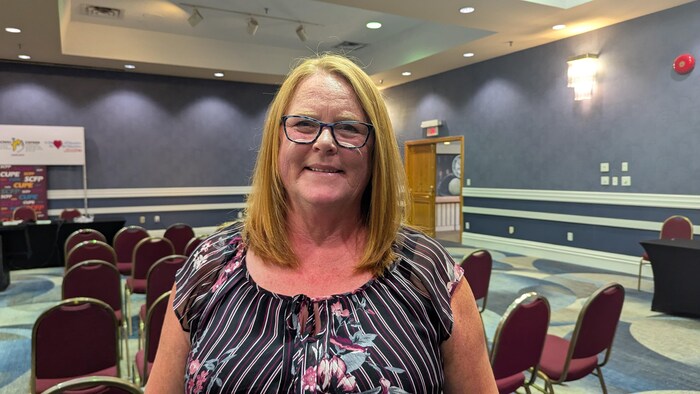 Sharon Teare pose pour la photo dans une salle de conférence.