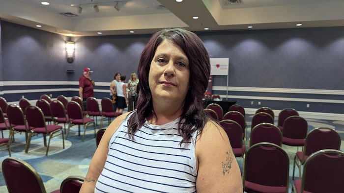 Christine Robichaud pose pour la caméra dans une salle de réunion.