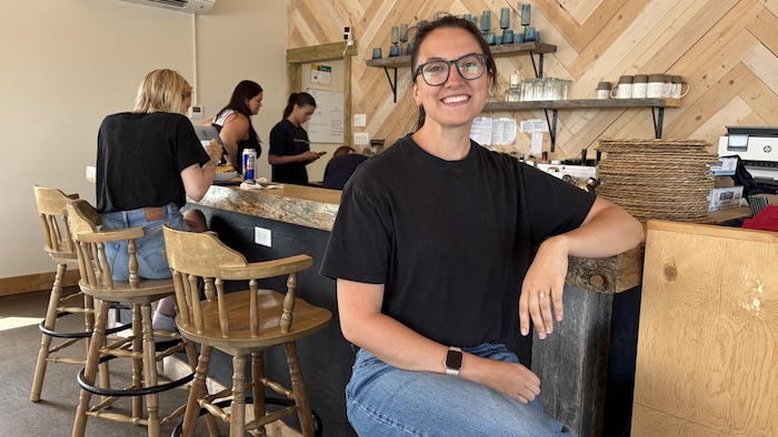 Une femme assise près d'un comptoir d'un restaurant.