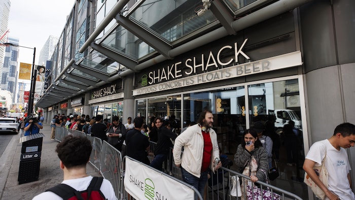Des gens font la queue devant un restaurant Shake Shack.