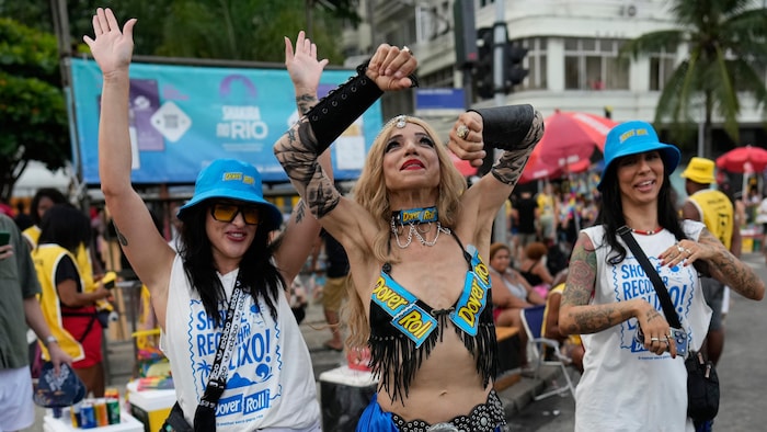 Trois Brésiliennes dansent dans les rues.