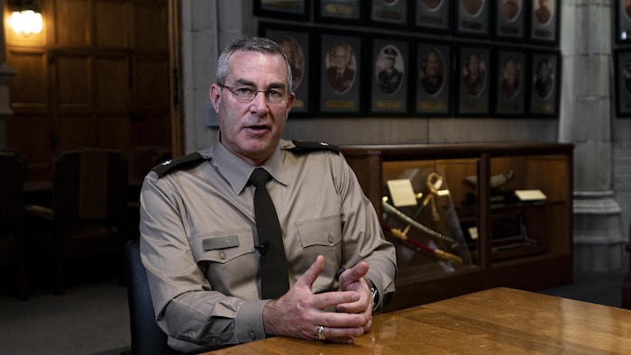 Un homme en habit militaire discute à une table