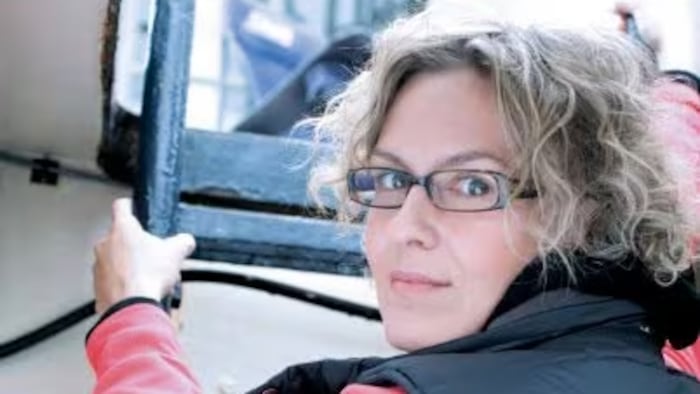 Shannon Mann qui attrape avec ses deux mains une échelle pour sortir la cale d’une embarcation. 
