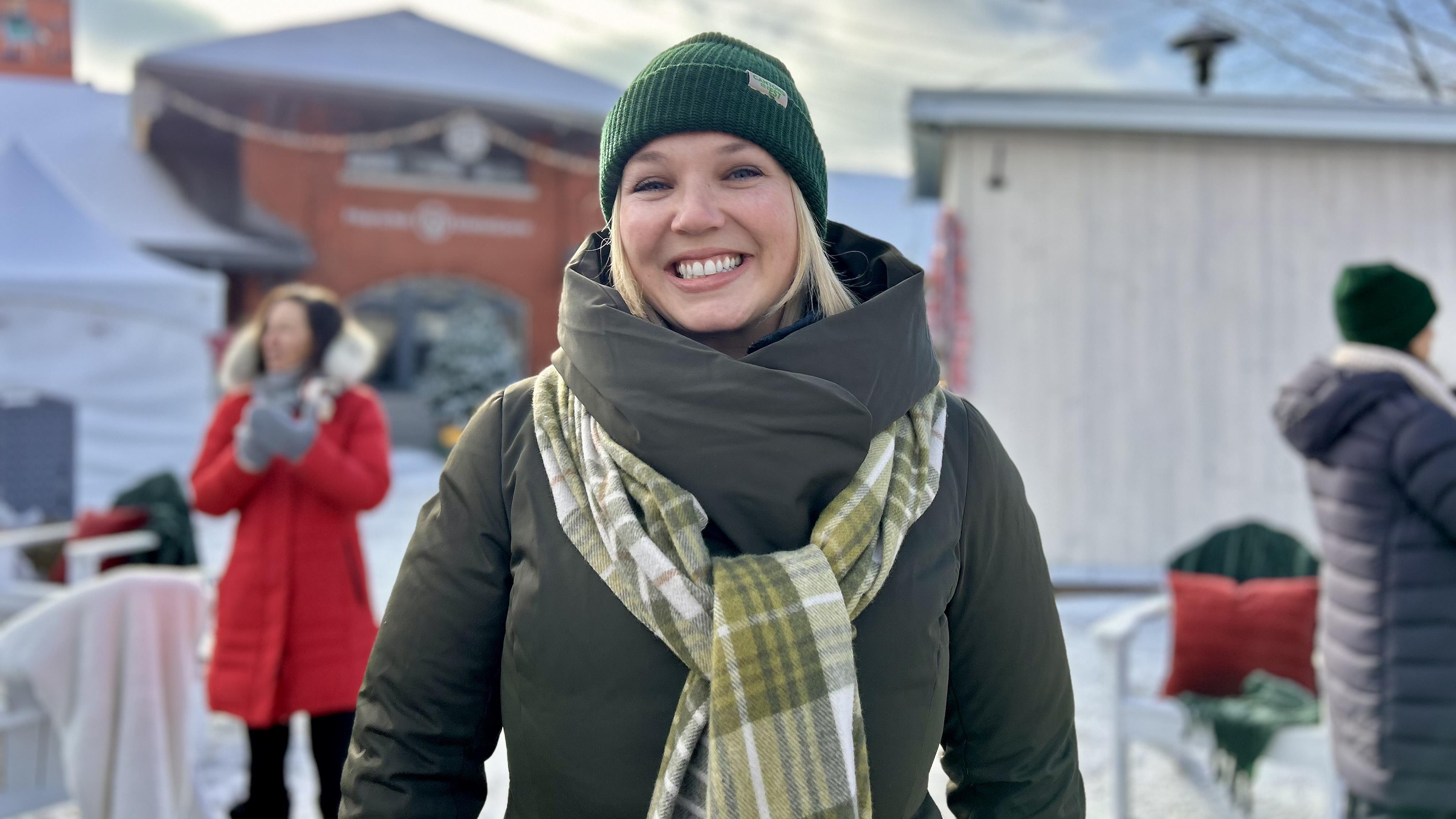 Shanny Hallé sourit au milieu du marché de la gare en hiver.
