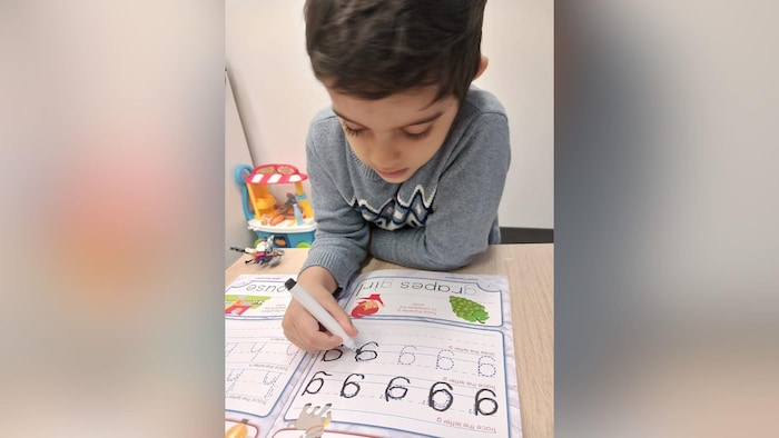 Un jeune garçon travaille sur des devoirs.