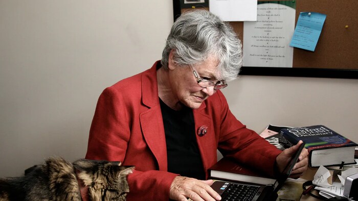 La dramaturge Sharon Pollock est assise devant son ordinateur avec son chat.