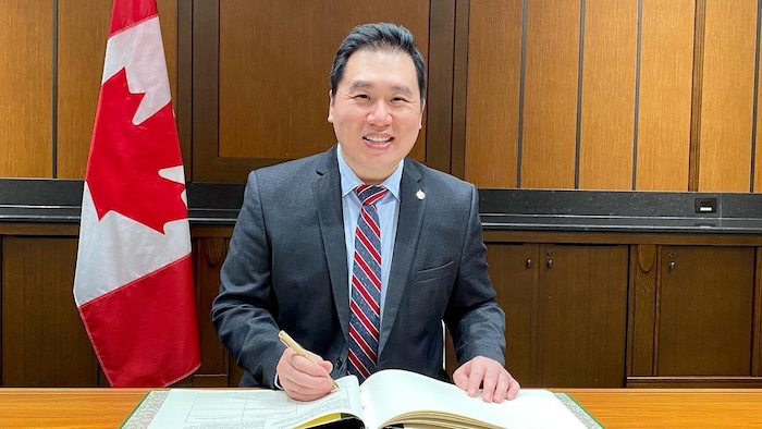 Shaun Chen devant un grand livre.