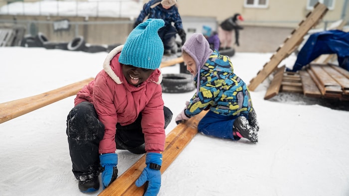 Deux enfants soulèvent un madrier.
