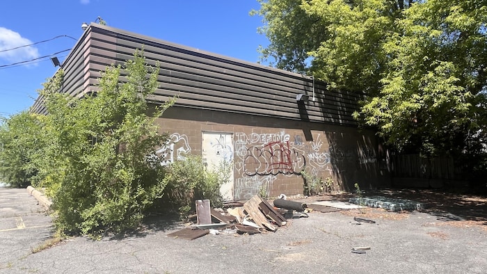Des déchets jonchent le sol un peu partout derrière l'ancien Tim Hortons