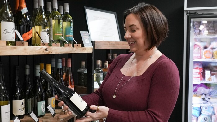 Shawna Grey tenant une bouteille de vin dans un magasin à Kelowna, le 20 février 2026.