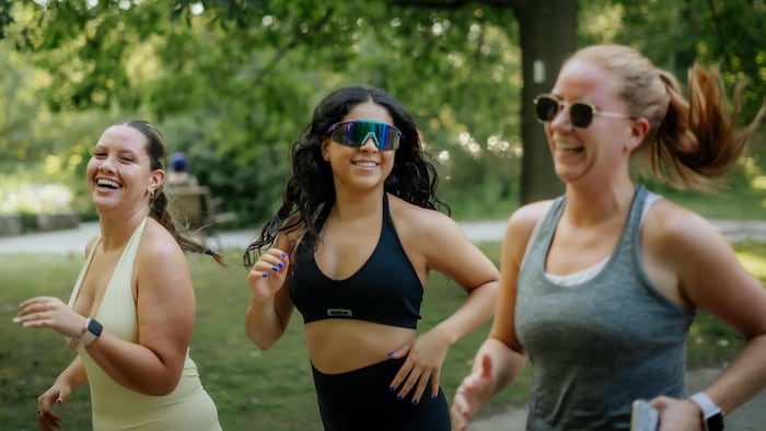 Isabella Ramirez, au centre, court aux côtés de deux participantes de She Runs London dans un parc à London.