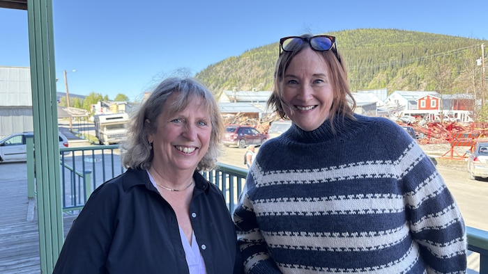 Deux femmes souriantes posent côte à côte pour la caméra.