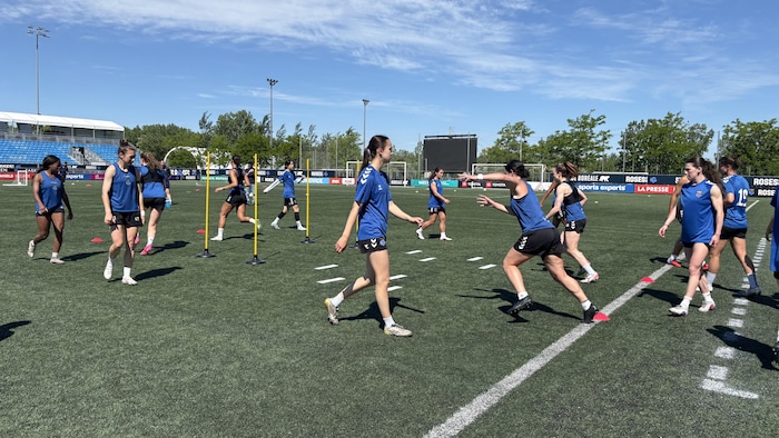 Des joueuses sont à l'entrainement sur le terrain de soccer.