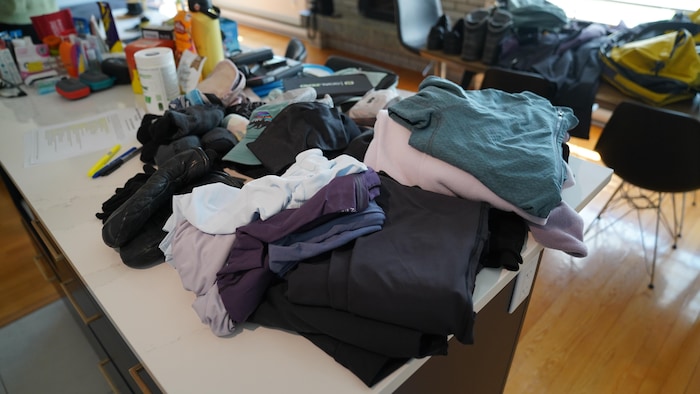 Les vêtements et l'équipement qu'elle apporteront étalés sur la table.