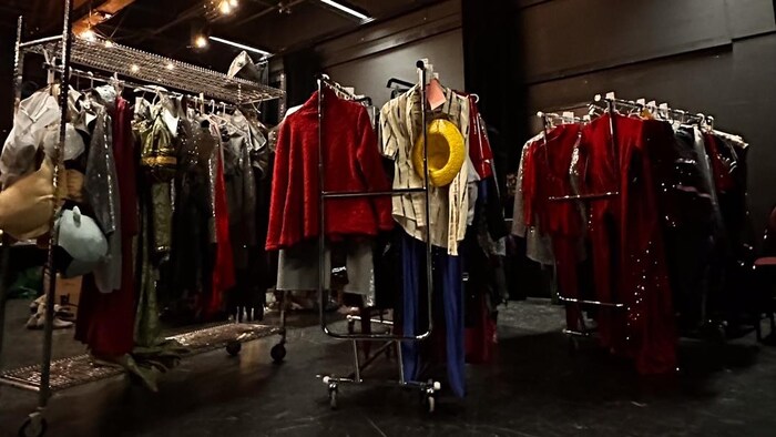 Plusieurs présentoirs de costumes de scène.