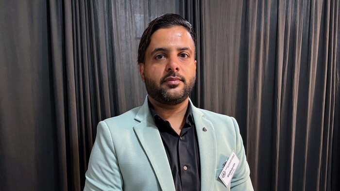 Le pharmacien Sidharth Arora est debout devant un rideau.