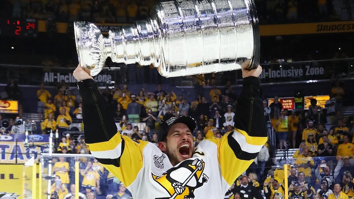 Sidney Crosby portant fièrement la Coupe Stanley.